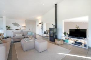 a living room with a couch and a tv at Super VIP Waterfront Villa - 4p - Waterzicht & Windbeschut Terras - Villa 42 in Ouddorp