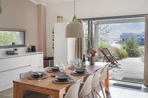 a kitchen and dining room with a table and chairs at Super VIP Waterfront Villa - 4p - Waterzicht & Windbeschut Terras - Villa 42 in Ouddorp