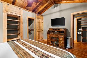 a bedroom with a bed and a desk with a television at The Elk's Apple Grove, Upper Suite, Real Log Cabin in Maggie Valley +10 photos