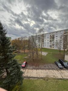 a parking lot with cars parked in front of a building at Ďumbierska Sásová Apartment in Otilia