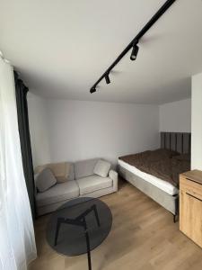 a living room with a couch and a table at Ďumbierska Sásová Apartment in Otilia