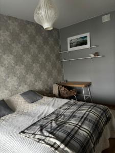 a bedroom with a bed and a desk in it at Cozy two-room apartment in the center of Rovaniemi in Rovaniemi