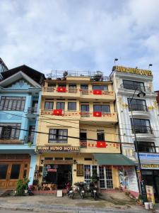 a tall yellow building with a sign on it at Minh Hưng Hostel in Sa Pa