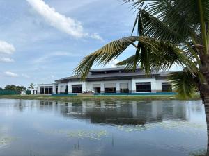 a building with a palm tree in front of a body of water at The Mangrove at Carey Circles 