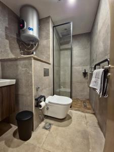 een badkamer met toilet en douche bij Modern ZED Apartment Near Pyramids, ZED Park, GEM in Sheikh Zayed
