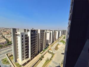 een luchtfoto van een stad met hoge gebouwen bij Modern ZED Apartment Near Pyramids, ZED Park, GEM in Sheikh Zayed