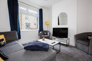 a living room with a couch and a tv at Connaught Stays - Home from Home in Preston