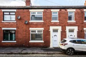 a white car parked in front of a brick house at Connaught Stays - Home from Home in Preston