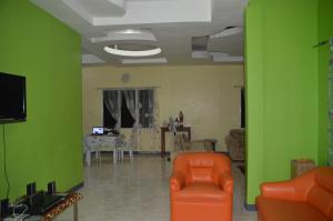 a living room with green walls and an orange chair at James Homestay in Siquijor