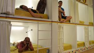 a man sitting on a bed in front of a mirror at Ringo's Foyer in Melaka