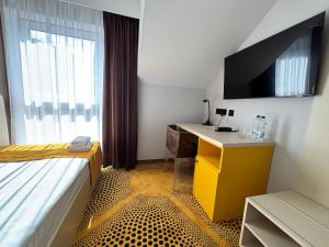 a hotel room with a desk and a tv at Eclipse Budget Rooms in Domasław +2 photos