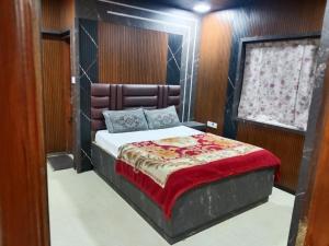 a bedroom with a bed with a padded headboard at Krishna residency in Ooty