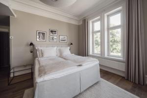 a white bedroom with a large bed and two windows at TwentySix in Malmö