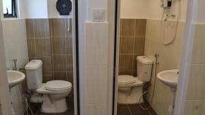 a bathroom with two toilets and a sink at Ringo's Foyer in Melaka