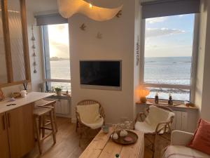 ein Wohnzimmer mit Tisch und Blick auf das Meer in der Unterkunft Suite hôtelière face à la mer in Santec
