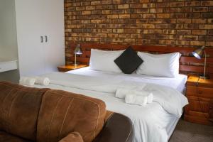 a bedroom with two beds and a brick wall at The Albatros Guesthouse in Margate +23 photos