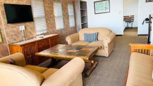 een woonkamer met stoelen, een tafel en een tv bij The Albatros Guesthouse in Margate