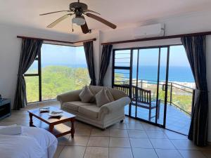 een woonkamer met een bank en uitzicht op de oceaan bij The Albatros Guesthouse in Margate