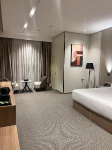 a hotel room with a bed and a desk and chair at فندق دبليو سويتس القنفذة in Al Qunfudhah