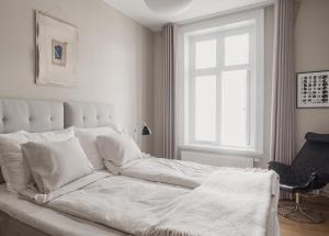 a white bed in a white bedroom with a window at TwentySix in Malmö