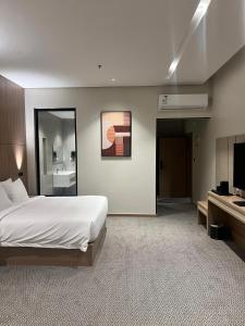 a hotel room with a bed and a television at فندق دبليو سويتس القنفذة in Al Qunfudhah