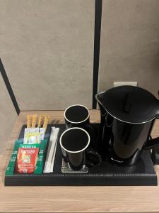 a tray with two pots and cups on a table at فندق دبليو سويتس القنفذة in Al Qunfudhah