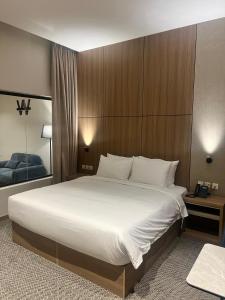 a bedroom with a large bed with white sheets at فندق دبليو سويتس القنفذة in Al Qunfudhah