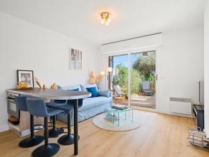 a living room with a blue couch and a table at Le Cocon - 5 min to Monaco - Ideal couple or business - Free private parking - Near events - Terrace and balcony - Premium services in Fontvieille