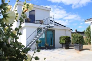 une maison blanche avec un escalier en face de celle-ci dans l'établissement Studio Art-hill, à Jabbeke