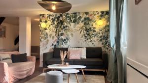 a living room with a couch and a table at Le Printemps  +17 photos