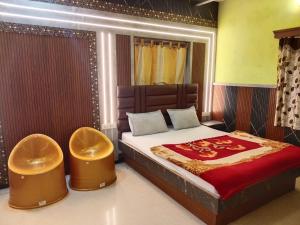 Un dormitorio con una cama grande con dos taburetes. en Krishna residency, en Ooty