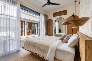 ein Schlafzimmer mit einem großen Bett und einem großen Fenster in der Unterkunft Villa Marcel Premium by Tofino Villas in Uluwatu + 27 Fotos