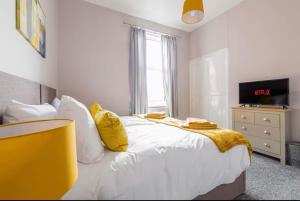Un dormitorio con una cama con una manta amarilla encima. en Carnarvon Stays - 2 bed home, en Preston 15 fotos más