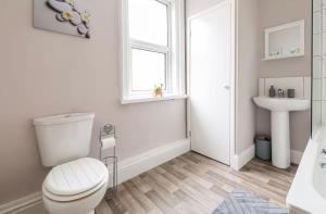 Un baño blanco con inodoro y lavabo. en Carnarvon Stays - 2 bed home, en Preston