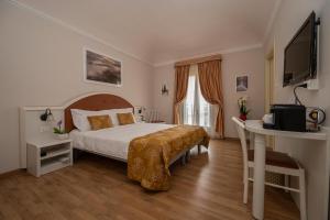 een slaapkamer met een bed, een bureau en een televisie bij Casa Faccioli Luxury B&B & Wellness in Bologna