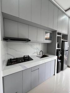 una cucina bianca con lavello e fornello di Ametys 1 Villa - Cozy 2BR Villa with Private Pool & Prime Seminyak a Seminyak