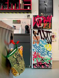 a kitchen with a refrigerator with graffiti on it at Le Loft des Cévennes in Ganges +28 photos