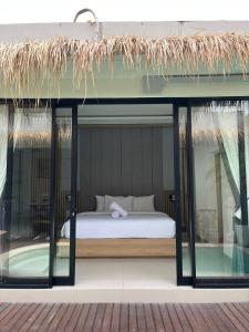 una camera con letto e finestra in vetro di Ametys 1 Villa - Cozy 2BR Villa with Private Pool & Prime Seminyak a Seminyak Altre 4 foto