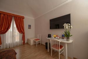 een woonkamer met een witte tafel met een vaas met bloemen bij Casa Faccioli Luxury B&B & Wellness in Bologna