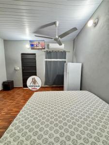 Habitación con ventilador de techo y nevera. en Hospedaje Ñande Roga, en Asunción