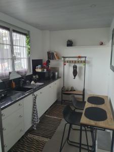 a kitchen with white cabinets and a table and chairs at Pleasant little cottage in Pont-sur-Yonne