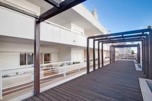 ein Holzsteg, der zu einem Gebäude mit Balkon führt in der Unterkunft T2 Santa Luzia F in Santa Luzia