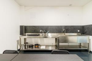 een keuken met een wastafel en een tafel en stoelen bij Kapselhotel nähe Hauptbahnhof Halle-Saale in Halle an der Saale +49 foto's