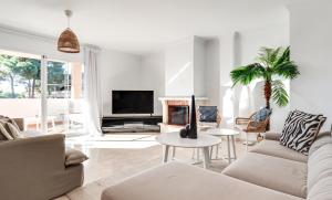un salon avec un canapé et une télévision dans l'établissement Center beach 2 beds Appartement Elviria, à Marbella