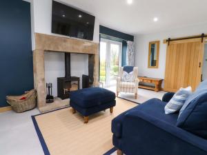 InskipにあるBrook Houseの青いソファと暖炉のあるリビングルーム
