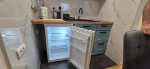 a kitchen with an open refrigerator and a sink at Apartman Blue in Subotica