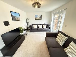 un salon avec un canapé et une télévision dans l'établissement Cayton Bay Cottage, à Cayton