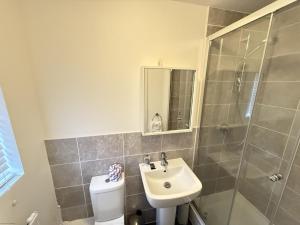 une salle de bain avec toilettes, lavabo et douche dans l'établissement Cayton Bay Cottage, à Cayton 33 autres photos