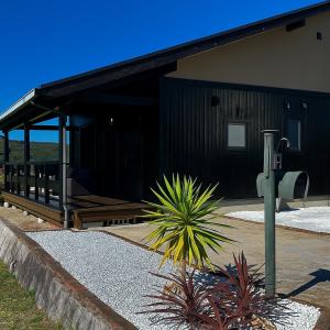 un edificio nero con una pianta di fronte di Setouchi Retreats Sera Highlands 