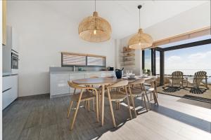 eine Küche und ein Esszimmer mit Tisch und Stühlen in der Unterkunft Luxury Waterfront Retreat 4p - Comfort & Panoramisch Uitzicht - Villa 13 in Ouddorp